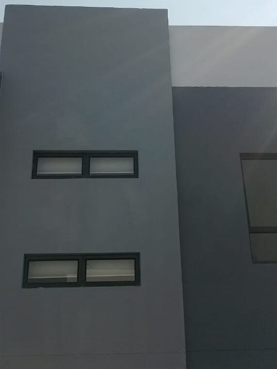 The same building after repainting in charcoal and grey